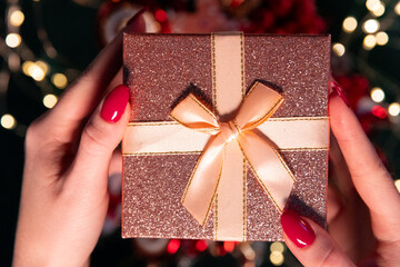 An elegant gift held by a woman against a dark backdrop adorned with twinkling lights. Perfect for...