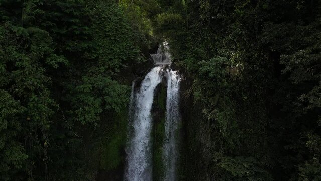 Moving close toward Gitgit waterfall in the North of Bali, Indonesia. Aerial.