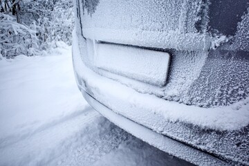 Snow-covered car license plate. Car movement in snowfall.