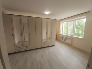 a room with a bright and clean classic background of walls, light parquet floor, details of home furniture