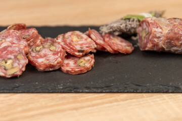 Chorizo ​​sausage and salami, delicate cut. spanish salami on black background with spices, paprika, pepper. Spicy food. red pepper.