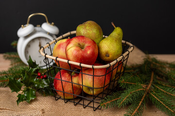 Apples and pears in a metal basket, juicy fruits on the background, fresh and tasty
