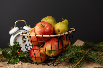 Apples and pears in a metal basket, juicy fruits on the background, fresh and tasty