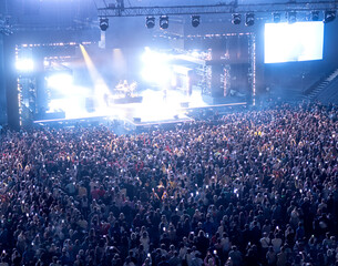 crowd of people at a concert in a huge concert hall