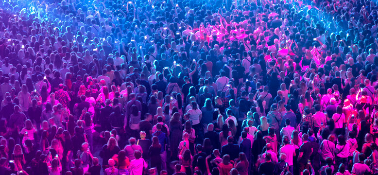 crowd of people at a concert in a huge concert hall