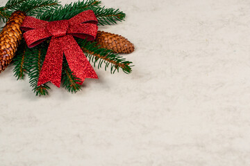 Christmas background with pine branches, pine cones and red ribbon