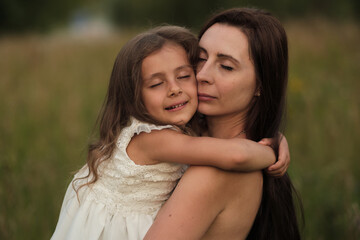 A girl's elated expression as she hugs her mom near the woods. Against screen addiction, nature offers genuine moments.