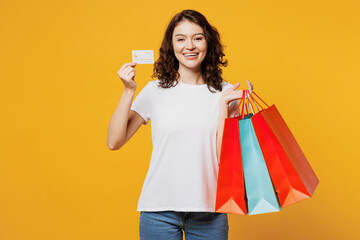 Young woman wears t-shirt casual clothes hold in hand paper package bags after shopping show credit...