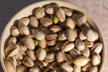 Pistachio nuts with wooden bowl