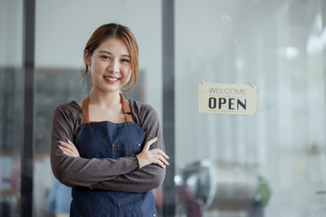 Happy smelling Asian woman owner with open sign broad and ready to service, Small startup business...