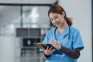 Happy asian female doctor holding a patient clipboard standing in hospital, Medicine and healthcare concept.