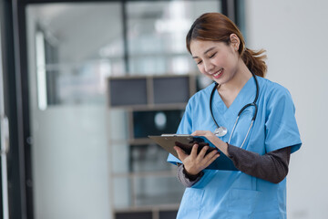 Happy asian female doctor holding a patient clipboard standing in hospital, Medicine and healthcare...