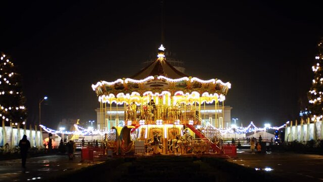 Beautiful Venetian carousel in a amusement park. Illuminated classic merry go round at night