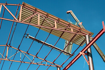 installation of hangar metal structures using a crane and installers, against the background of a...