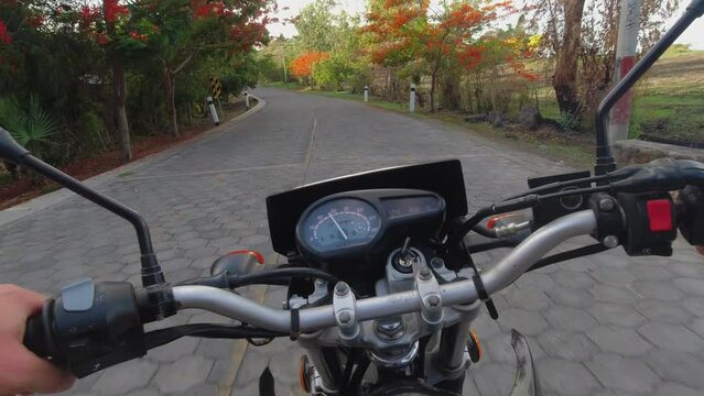 Motorcycle POV: Driving paving stone road in autumn color foliage