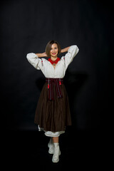 beautiful ukrainian brunette smiling woman in ukrainian vintage traditional dress embroidery and red necklace posing  on black background 
