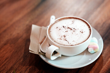Hot coffee with soft milk foam on the table in a cafe.
