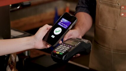 Unrecognizable hands of customer female using credit card to pay for goods or a cup of coffee in eatery cafe shop with cash register machine, technology cashless wireless transaction payment lifestyle - Powered by Adobe