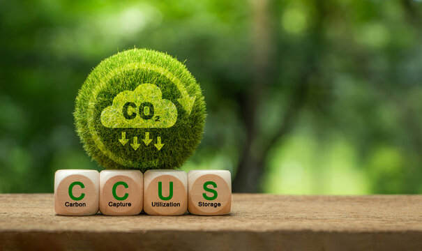 Carbon Capture, Utilization and Storage (CCUS) concept. Words CCUS on a wood block and Green earth with world map. Technology of CO2 capturing and store. Net zero target, limit global warming.