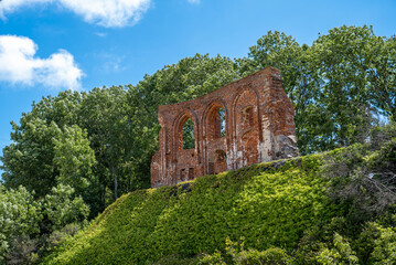The photograph shows sunken fragments of the Church of St. Nicholas in Trzęsacz, which are a symbolic historical souvenir in contrast with the Baltic coast.
