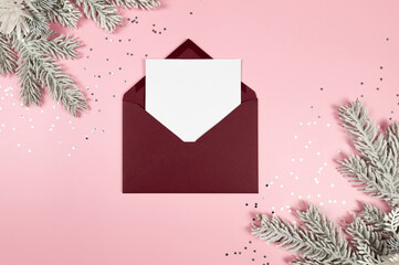 Christmas composition, black envelope, white card, fir tree branches, silver stars confetti on pink background. Christmas, New Year, winter concept. Top view, flat lay, copy space. 
