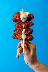 Fried Chicken Hot Wing Being Dipping With Cool Ranch Sauce, Royal Blue Background, Editorial...