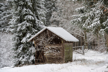 Winterlandschaft, schneebedeckt - alte hölzerne Blockhütte mit Schneefall