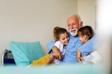 Happy grandfather and his grandchildren laughing and enjoying leisure time together.
