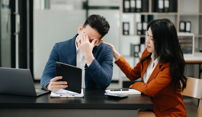 Furious two Asian businesspeople arguing strongly after making a mistake at work .