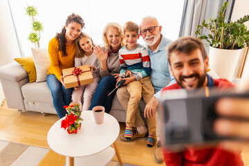Multi-generation family taking selfie while celebrating Christmas at home