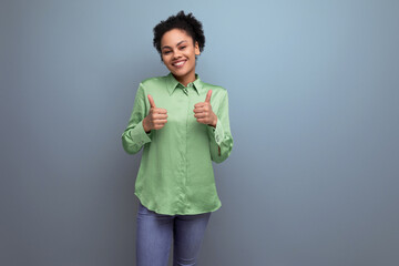 young positive smiling hispanic brunette lady dressed in a green stylish shirt on the background with copy space