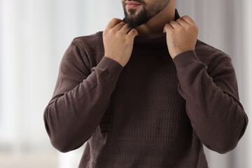 Man in stylish sweater against blurred background, closeup