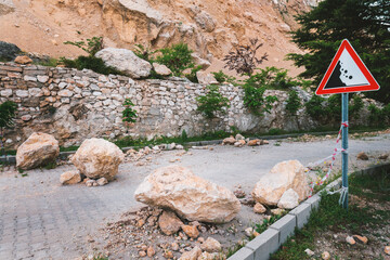 Rockfall on road. Large rocks of rock fell on the asphalt road. Scattered stones on road....