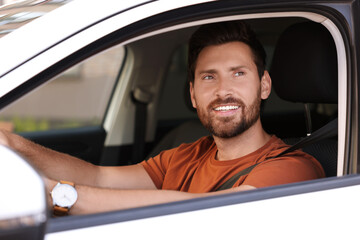 Enjoying trip. Happy bearded man driving his car, view from outside