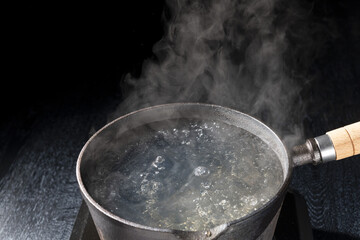 鉄鍋でお湯を沸かし沸騰した場面