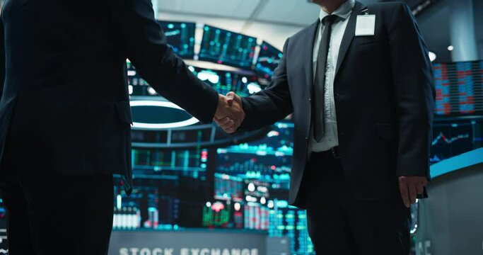 Strong Handshake by Two Stock Exchange Managers. Investment Trader and Broker Agree on Profitable Buy and Sell Orders, Shake Hands to Seal the Deal. Anonymous Specialists Working in a Trading Agency