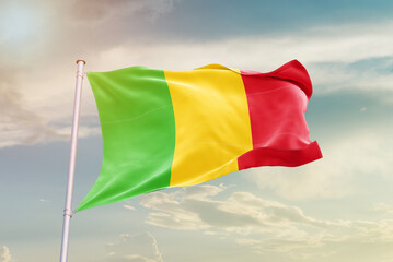Mali national flag waving in beautiful sky. The symbol of the state on wavy silk fabric.