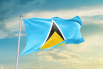 Saint Lucia national flag waving in beautiful sky. The symbol of the state on wavy silk fabric.