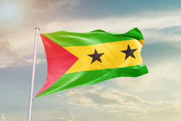 Sao Tome and Principe national flag waving in beautiful sky. The symbol of the state on wavy silk fabric.