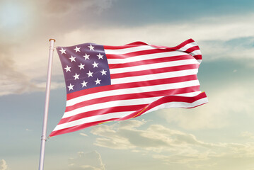 United States national flag waving in beautiful sky. The symbol of the state on wavy silk fabric.
