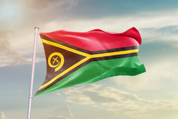 Vanuatu national flag waving in beautiful sky. The symbol of the state on wavy silk fabric.
