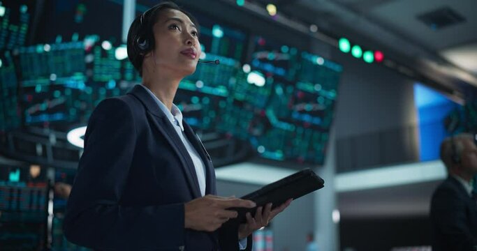 Portrait of a Young Beautiful Stock Exchange Broker Using Tablet Computer, Researching Real-Time Stocks Data, Analyzing Commodities and Exchange Market Charts. Professional Investment Trader in Office