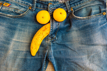 Potency problem concept.Mens denim pants with banana and lemons imitating male genitals.Health and...