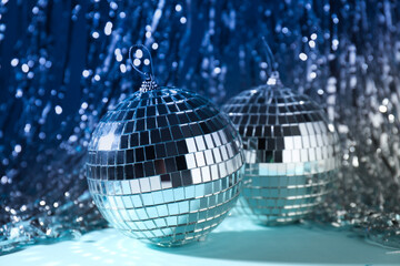 Disco balls with festive silver ribbons on background