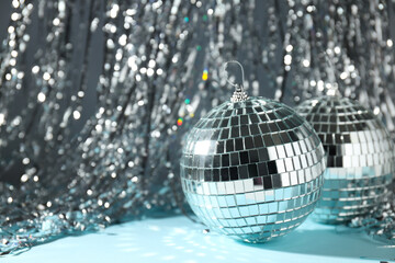 Disco balls with festive silver ribbons on background