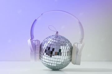 A beautiful disco ball with headphones on a light background