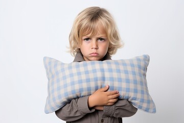 Dreamland Fatigue: Little Boy in Pajamas, Exhausted, Clutching a Pillow Against White Background