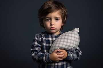 Dreamland Fatigue: Little Boy in Pajamas, Exhausted, Clutching a Pillow Against White Background