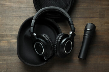 Black, large headphones, on the table with a microphone.