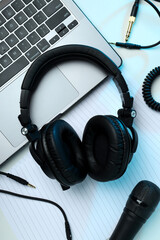 Big headphones, on a table with a laptop.